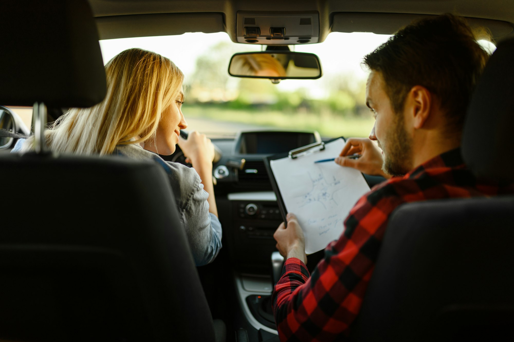 Instructor helps woman to drive the car