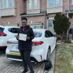 Student celebrating license with driving instructor Oakville, Bronte neighbourhood.