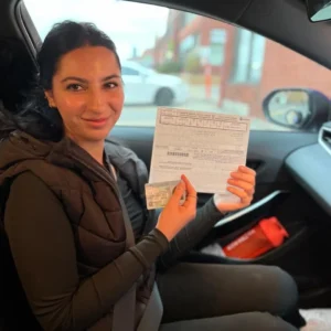 Happy student holding driving license inside car after driving lessons Mississauga, Downtown Mississauga.