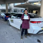 Happy student holding license after driving lessons Oakville, Downtown Oakville.