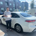 Student celebrating license with driving instructor Mississauga, Port Credit neighbourhood.
