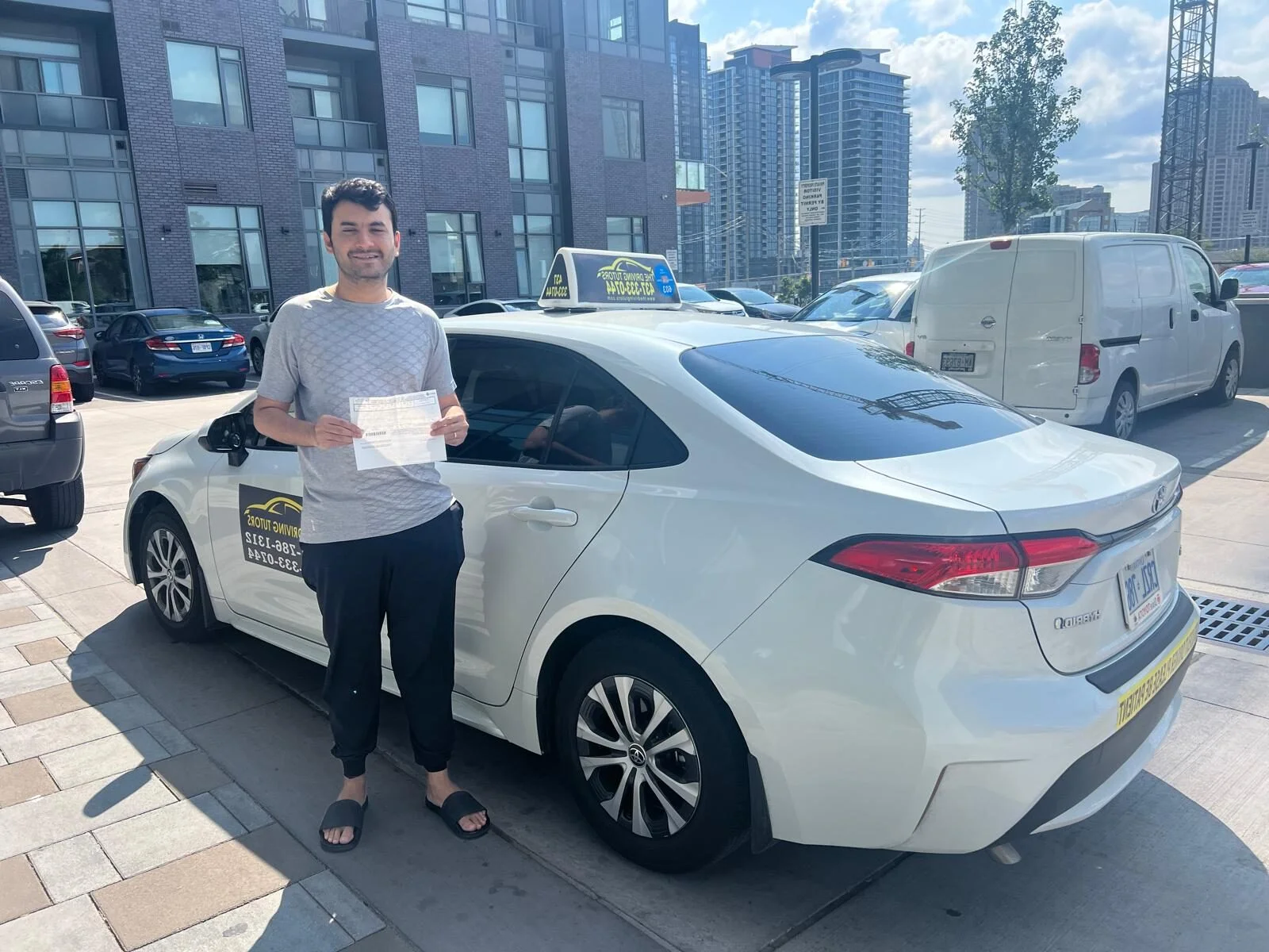 Student celebrating license with driving instructor Mississauga, Port Credit neighbourhood.